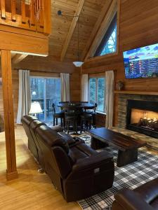 ヘンダーソンビルにあるThe Dream Road Escape Cabin and Hot Tubのソファと暖炉のあるリビングルーム