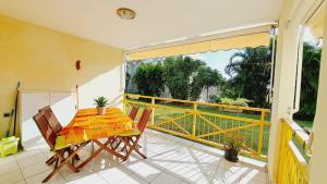 ein Balkon mit einem Tisch und Stühlen auf einem Balkon in der Unterkunft La Fleur des Caraïbes in Saint-Claude
