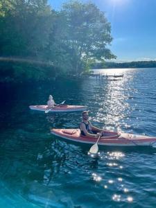 dos personas en kayaks en el agua en un lago en Escape to Tree House Island Life, en Monmouth