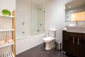 a bathroom with a toilet and a shower and a sink at Sleek Inner-City Getaway in Prime Location in Sydney