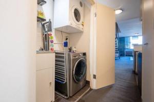 a kitchen with a washing machine in a room at Sleek Inner-City Getaway in Prime Location in Sydney