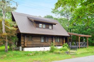 a log cabin with a porch and a deck at Rental Log Urube Village in Tsumagoi