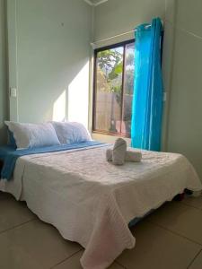 een bed met handdoeken in een kamer met een raam bij Casa Ula, en el corazón de Uvita in Uvita