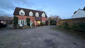 a large brick house with a brick driveway at Holly Cottage 