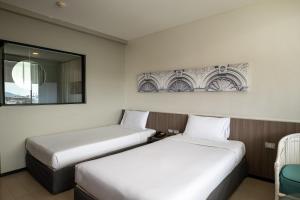 two beds sitting next to each other in a room at Pearl Hotel - SHA Plus in Phuket