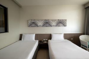 two beds sitting next to each other in a room at Pearl Hotel - SHA Plus in Phuket