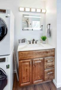 a bathroom with a sink and a washing machine at Tiny Home w/ King Bed mins DTWN in Rochester