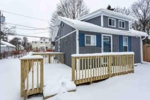 a small house with a fence in the snow at Tiny Home w/ King Bed mins DTWN in Rochester