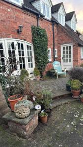 a brick house with potted plants in front of it at Holly Cottage 