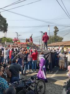 a crowd of people watching a man standing on top of a truck at Casa 27 in Antigua Guatemala