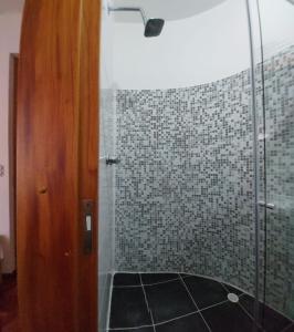 La salle de bains est pourvue d'une douche avec une porte en verre. dans l'établissement Casa Palermo Manizales, à Manizales