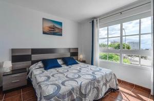 een slaapkamer met een bed en een groot raam bij Comfy Duplex For Family Vacations in Callao Salvaje
