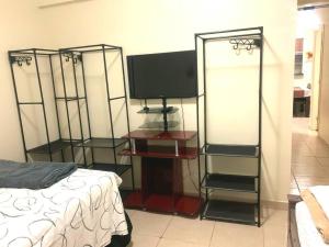 1 dormitorio con TV, cama y espejo en Apto Centro Wifi Shopping Garage, en Taubaté