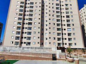 a tall building with a fence in front of it at Apto Centro Wifi Shopping Garage in Taubaté