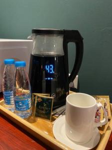 ein Holztablett mit einer Kaffeekanne und einer Kaffeetasse in der Unterkunft استديو بتصميم كلاسيكي أنيق ودخول ذاتي in Riad
