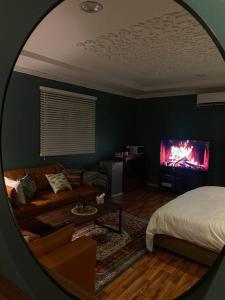Zimmer mit einem Bett und einem Wohnzimmer mit einem Spiegel in der Unterkunft استديو بتصميم كلاسيكي أنيق ودخول ذاتي in Riad