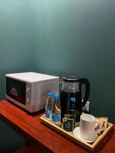 ein Tablett mit einer Kaffeemaschine und einer Mikrowelle in der Unterkunft استديو بتصميم كلاسيكي أنيق ودخول ذاتي in Riad