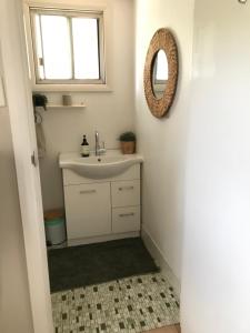 a bathroom with a sink and a mirror at HILLSIDE HAVEN CHARMING C1920 COTTAGE Pet Friendly Sleeps 1 - 6 in Broken Hill +18 photos