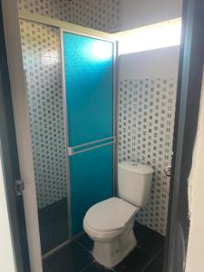 a bathroom with a toilet and a blue shower at Casa Quinta la excelencia in Melgar