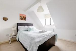 a white bedroom with a large bed with white sheets at Chic DuoRooms with Modern Comfort for Families in Kent