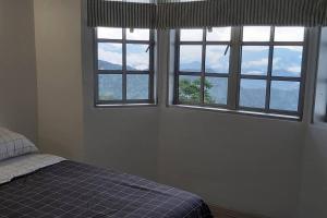 福隆港Silverpar B5-5-1 Mountain View(walk up 2 floor up)的一间卧室设有三扇窗户和一张床