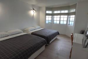 2 Betten in einem Zimmer mit 2 Fenstern in der Unterkunft Silverpar B5-5-1 Mountain View(walk up 2 floor up) in Bukit Fraser