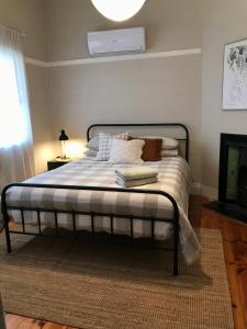 a bedroom with a bed with white sheets and pillows at HILLSIDE HAVEN CHARMING C1920 COTTAGE Pet Friendly Sleeps 1 - 6 in Broken Hill