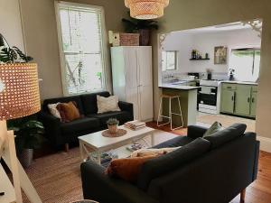 a living room with a couch and a table at HILLSIDE HAVEN CHARMING C1920 COTTAGE Pet Friendly Sleeps 1 - 6 in Broken Hill