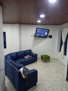 a living room with a blue couch and a flat screen tv at Casa Quinta la excelencia in Melgar