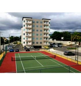 a tennis court in front of a building at Lovely 2 BedRoom c̅ Netflix across National Stadium Kingston in Kingston