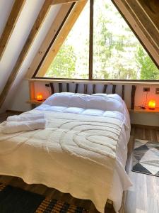 a bed in a room with a large window at Cabañas Ladera Sur in Melipeuco