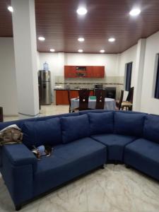 a blue couch in a living room with a kitchen at Casa Quinta la excelencia in Melgar