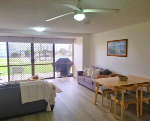 een woonkamer met een bank en een tafel bij The Poplars, Pool Access Getaway in Nelson Bay