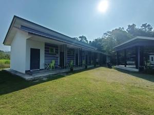 um edifício com um jardim de relva em frente em D' Surya Lavender Inn em Pantai Cenang