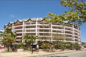 a large white building with trees in front of it at Hermoso apartamento con balcón cerca a la mejor playa in San Andrés