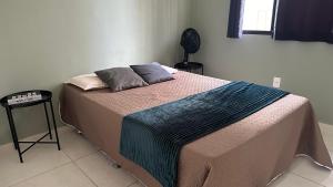 um quarto com uma cama com um cobertor em Studio Garden 01 Quartos em Caruaru