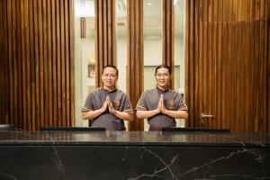 two men standing in front of a table with their hands at SN Residences in Vientiane
