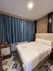 een slaapkamer met een groot bed en blauwe gordijnen bij Andi Hotel in Istanbul