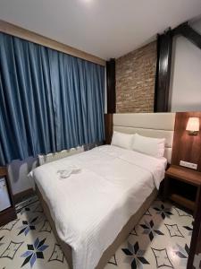 een slaapkamer met een groot wit bed en blauwe gordijnen bij Andi Hotel in Istanbul