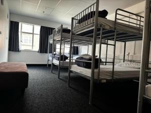 a room with three bunk beds in a building at Hotel Waterloo & Backpackers in Wellington