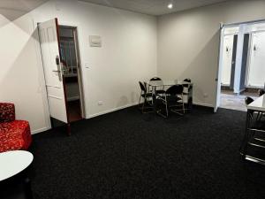een vergaderzaal met een tafel en stoelen en een bank bij Hotel Waterloo & Backpackers in Wellington