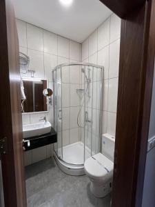y baño con ducha, aseo y lavamanos. en Andi Hotel, en Estambul