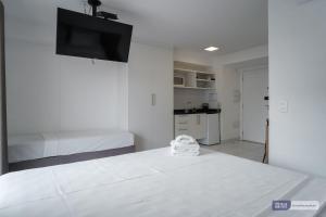 um quarto branco com 2 camas e uma televisão de ecrã plano em MH 50506 - Encantador Studio Expo CN Wi-FI/AC/VG em São Paulo