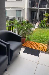 patio z kanapą i drewnianą ławką w obiekcie Studio Garden 01 Quartos w mieście Caruaru