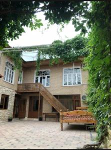 uma casa com um banco de madeira em frente em Fayz Guest House em Samarkand