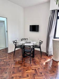 uma sala de jantar com uma mesa e cadeiras num piso de madeira em Departamento con vista al Abasto em Buenos Aires