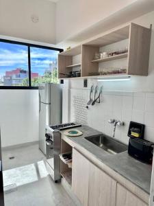 ブエノスアイレスにあるDepartamento con vista al Abastoのキッチン(シンク、コンロ付)、窓が備わります。
