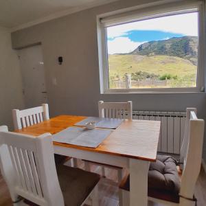 una mesa de comedor y sillas con una gran ventana en Los Coirones Aparts - El Chaltén - Patagonia en El Chaltén