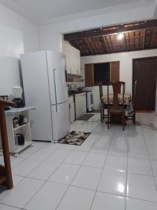 a kitchen with white tile floors and white appliances at Suíte com ar condicionado próximo ao Estádio Mangueirão in Belém