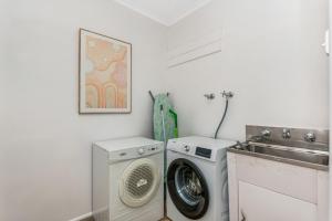 - une buanderie avec un lave-linge et un évier dans l'établissement Charming 3BR Home in Bendigo, à Kennington